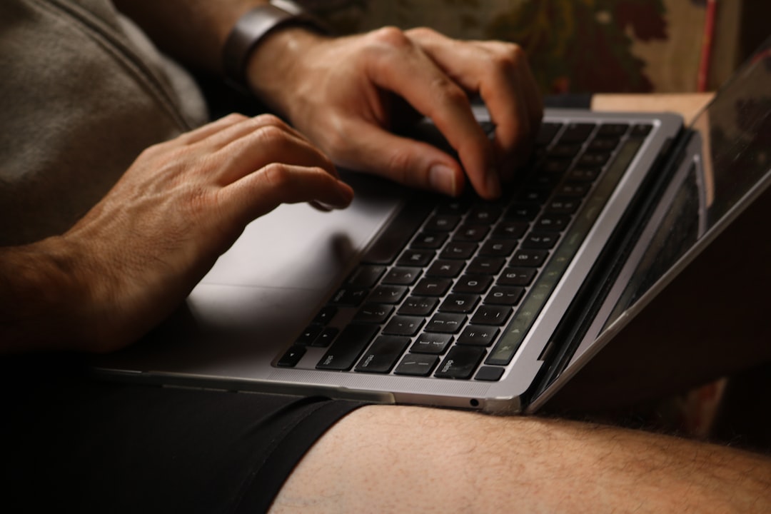 Person typing on a laptop computer keyboard.